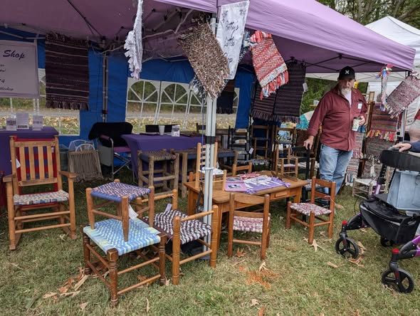Rugs hanging and chairs under the purple tent