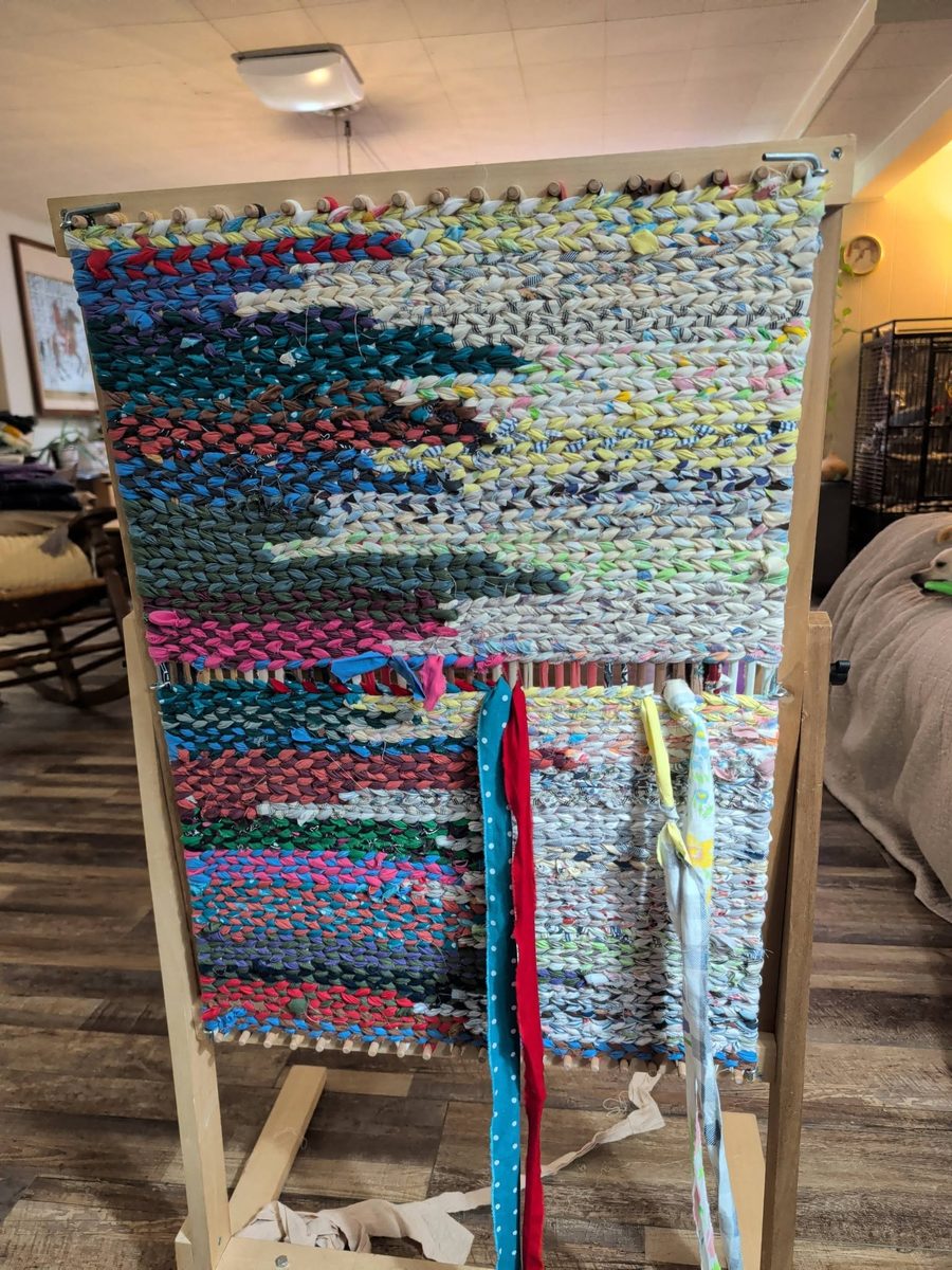 A twined rug in progress on a wooden twining loom