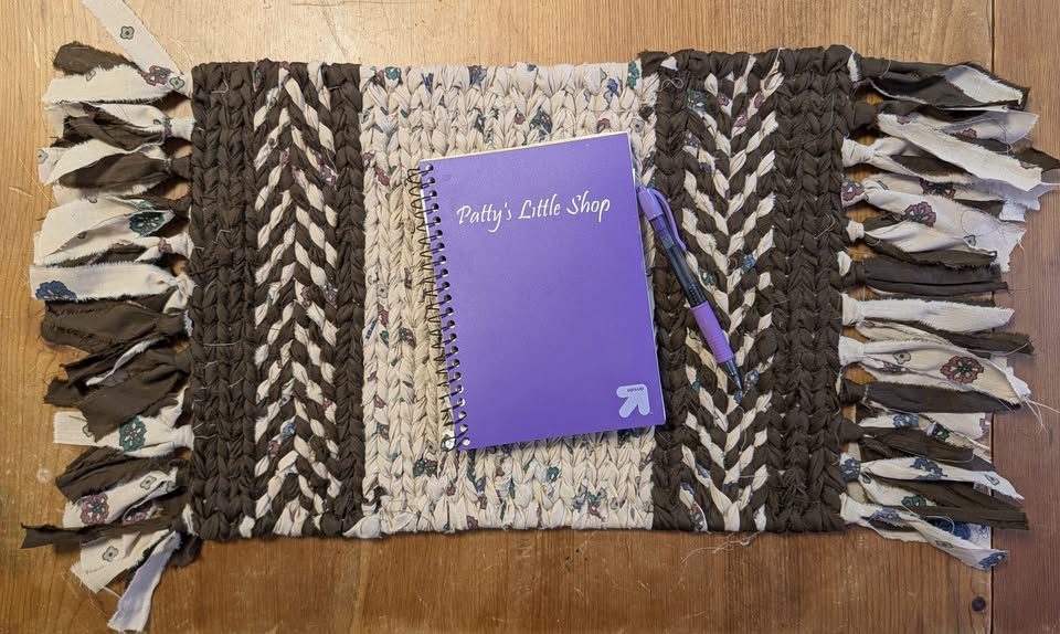 Twined rug in brown and cream with a braided pattern and fringe
