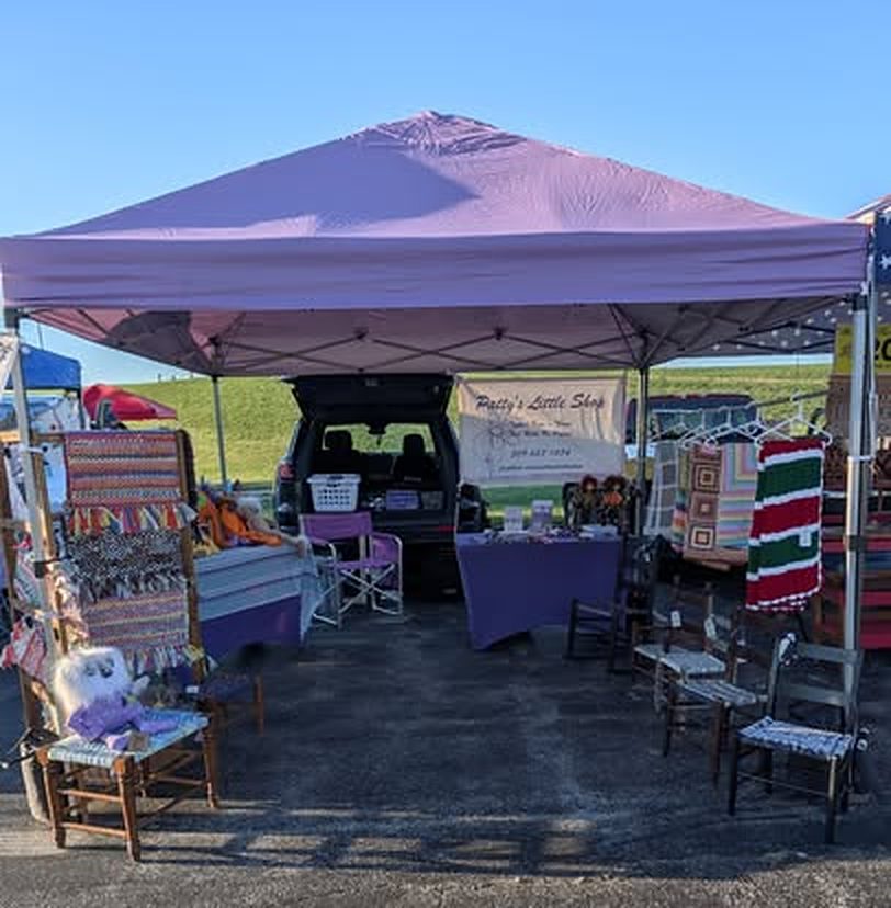 The purple tent set up with rugs and chairs